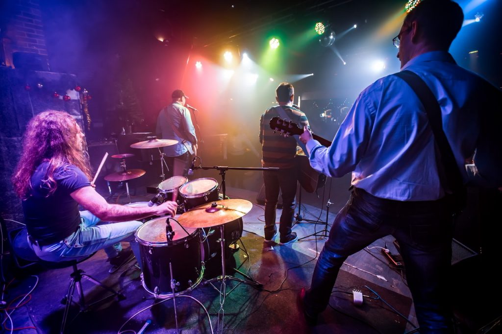 Band performs on stage, rock music concert in a nightclub. Authentic shooting with high iso in challenging lighting conditions. A little bit grain and blurred motion effects By cookelma