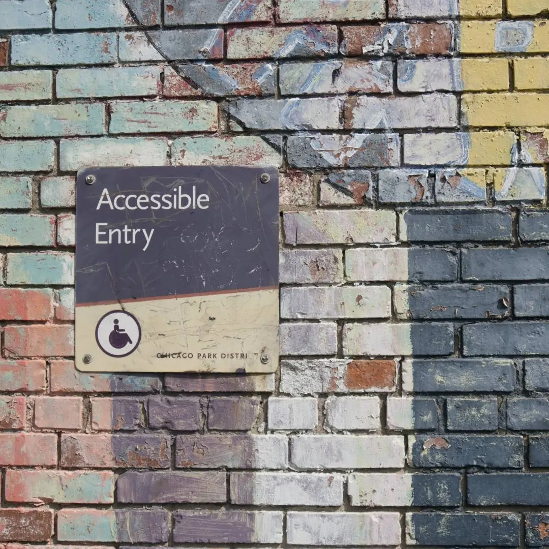 Accessible Entry sign on colourful brick wall.