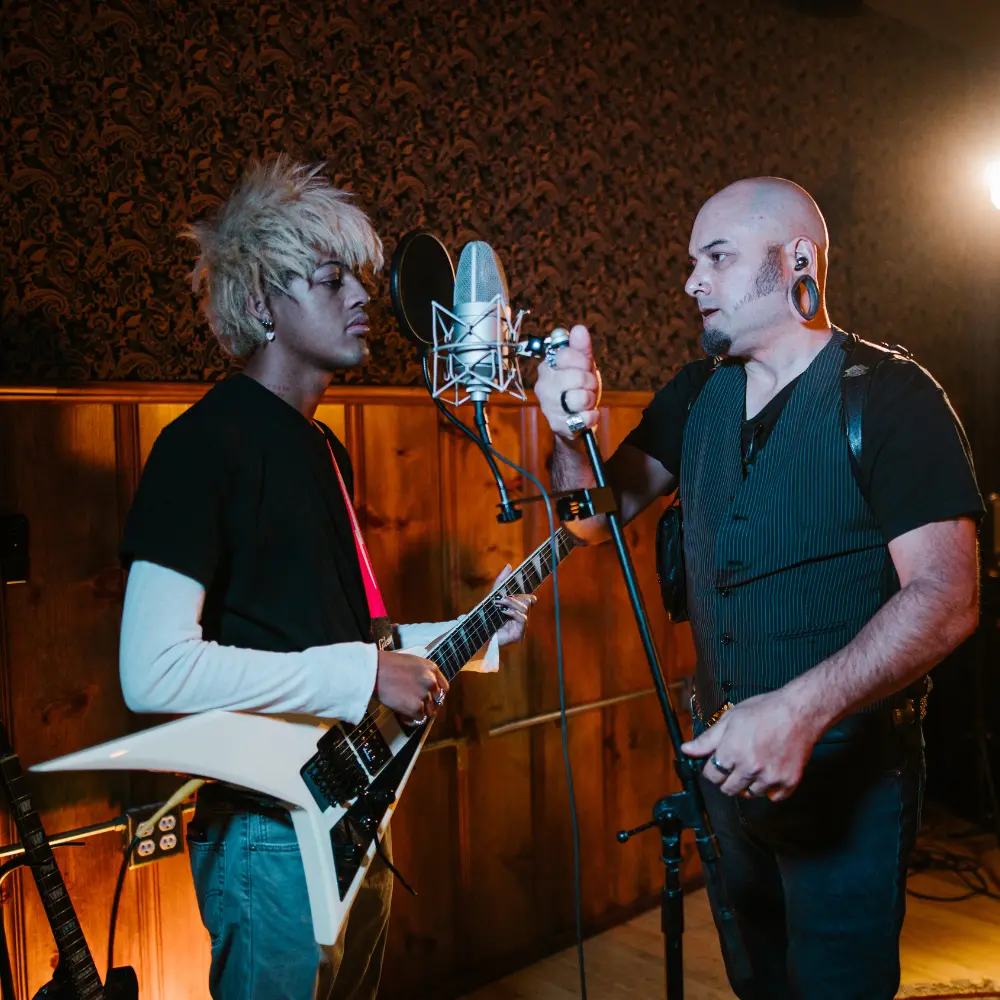 choosing music collaborators depicted with a guitarist and producer adjusting a microphone in a recording studio