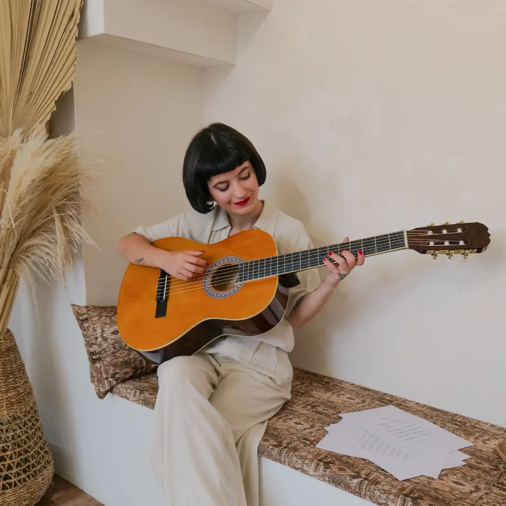 Independent music promotion is key for emerging artists, like this singer-songwriter playing an acoustic guitar in a cozy setting.