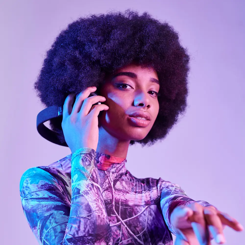 Music distribution strategies include branding and visuals, represented by this stylish DJ wearing headphones under neon lighting.