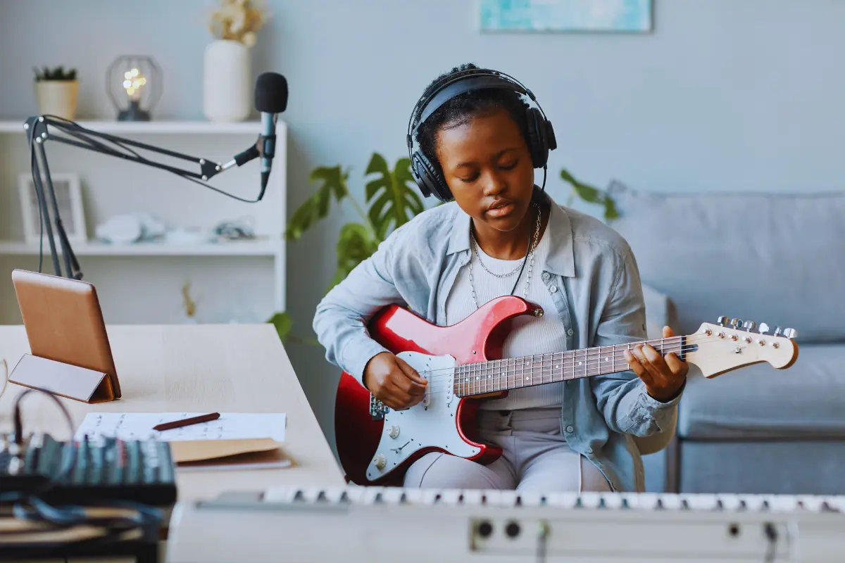 Music distribution tips help independent artists, like this young guitarist producing music in a home studio.