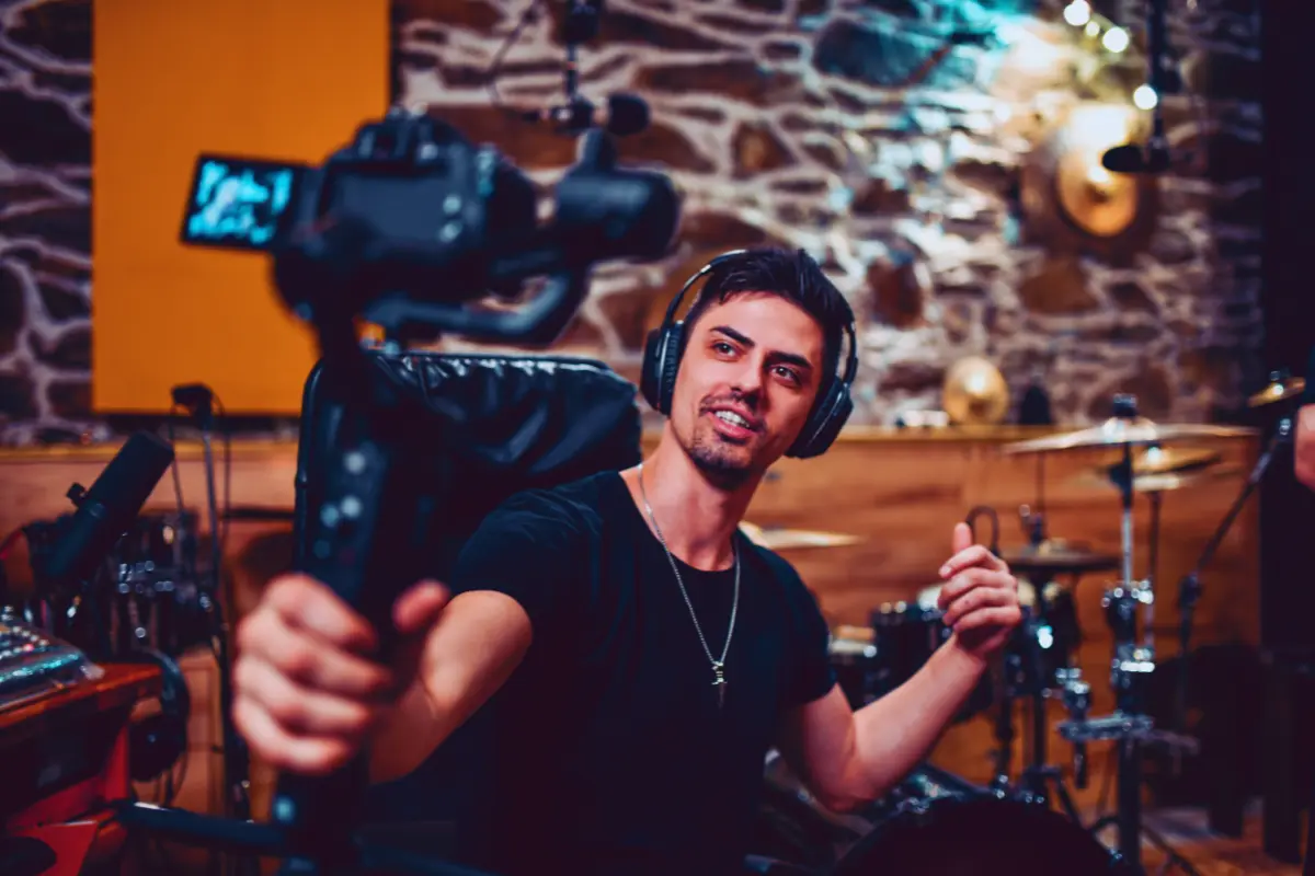 Music distribution is crucial for artists, as shown by a musician recording a video in a professional studio setup.