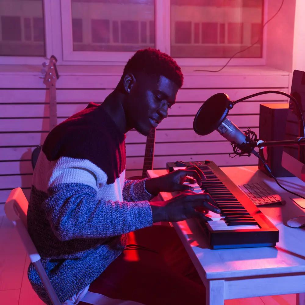 music project collaborators shown as a producer plays a MIDI keyboard in a home studio with atmospheric lighting.
