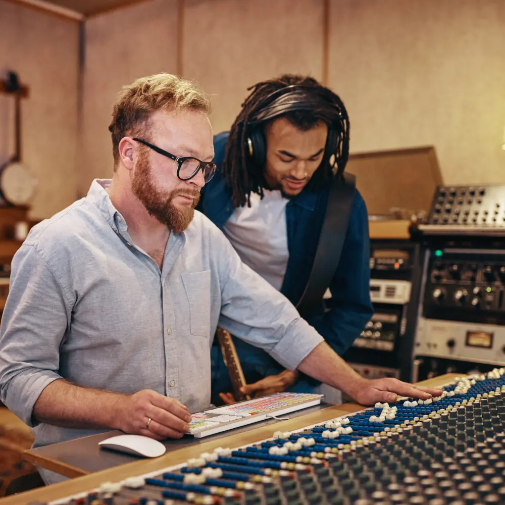 Musician livestream checklist in action with a producer and artist reviewing audio levels in a recording studio