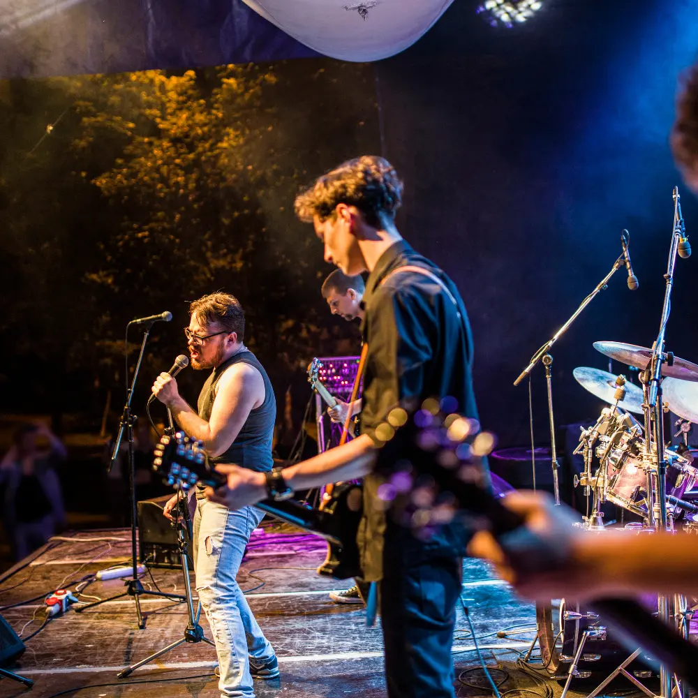 Promoting music on social media with a live band performing passionately on stage under colorful lights