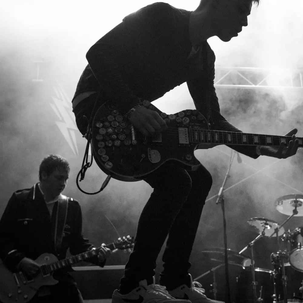 Music publishing revenue represented by band members performing with guitars on a smoky stage