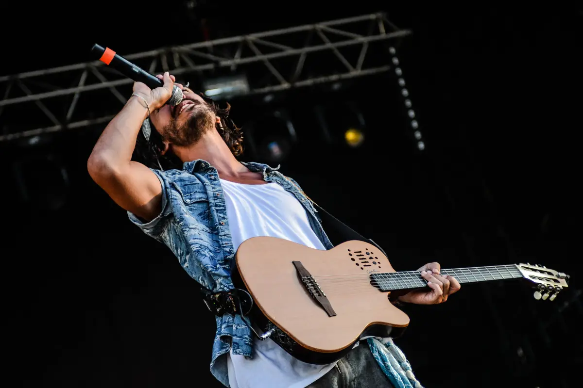 Songwriting collaboration online captured in an expressive solo performance by a singer with a guitar on stage